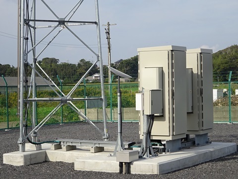 Equipment cabinets at the mast’s base, with a Starlink terminal beside them.