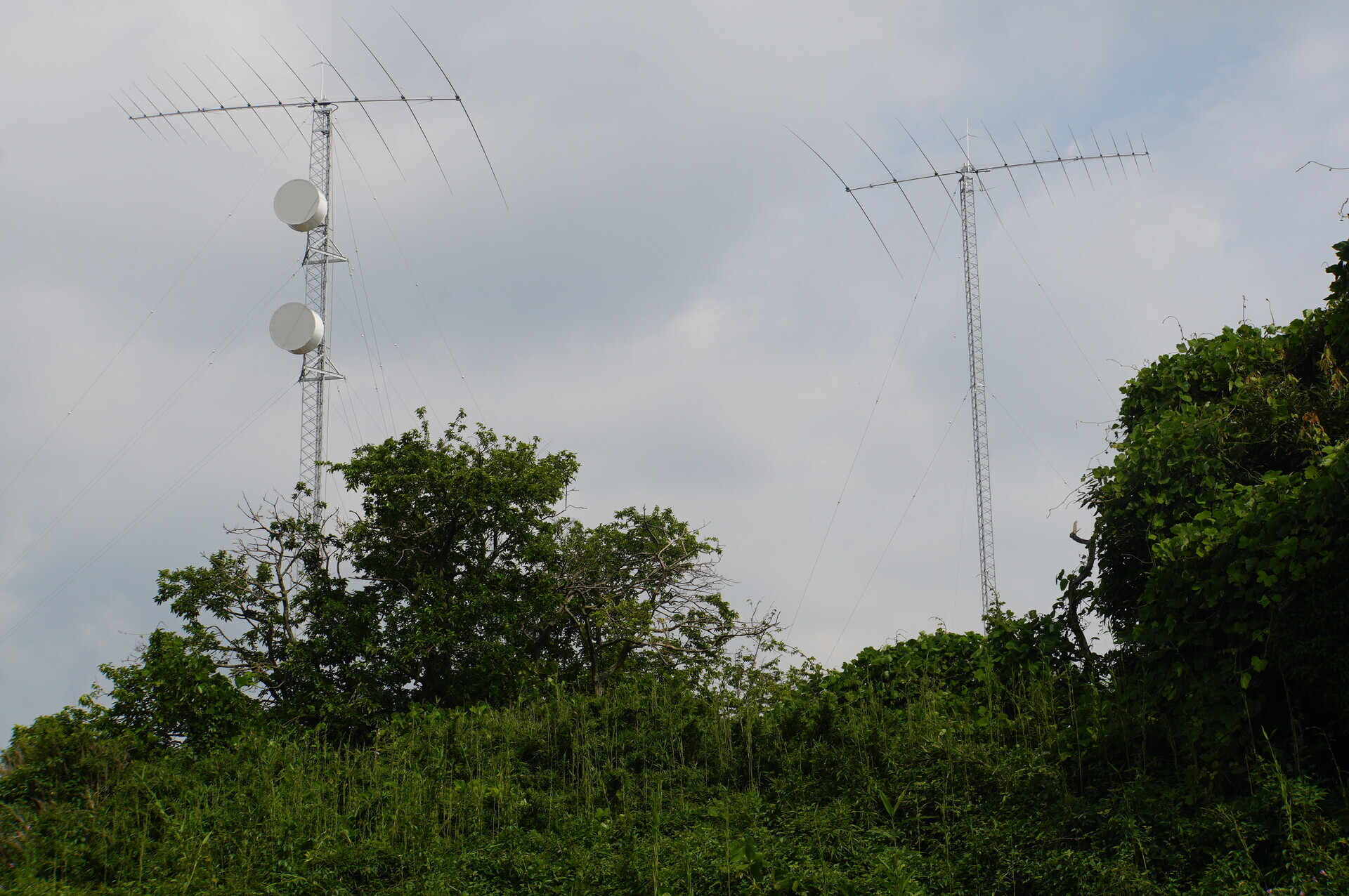 Shimoizumi under construction: two towers, each with a twelve-element HF array. The western tower on the left also carries the microwave dish pair.